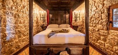 Historic medieval castle hotel with stone walls and arched windows perched atop a hilltop in Obidos, Portugal at golden sunset