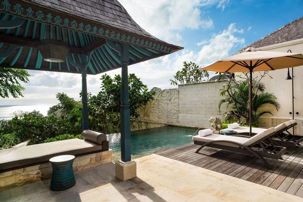 Luxurious oceanfront villa featuring infinity pool overlooking Bali coast, contemporary Javanese architecture with teak accents