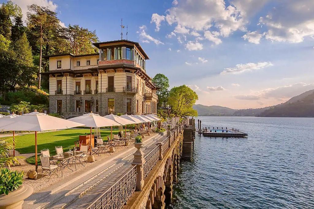 Elegant luxury hotel perched above Lake Como, featuring stone balconies, manicured gardens and panoramic views of Italian Alps