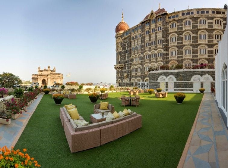 Historic Taj Mahal Palace Hotel in Mumbai with grand red-domed architecture, white colonial facades, palm trees and luxury entrance