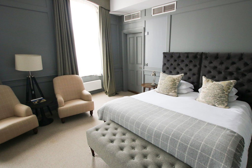 Spacious feature room at Kings Head Hotel with elegant king bed, plush furnishings, hardwood floors, and sophisticated decor in a classic United Kingdom style