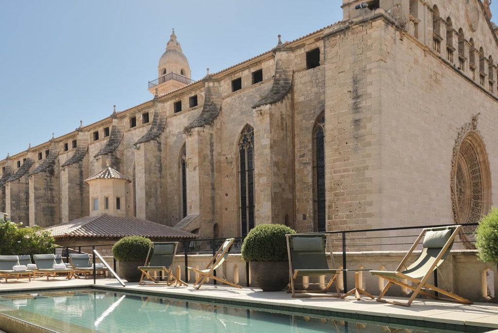 Elegant boutique hotel in Palma, Majorca, with restored historic stone facade, luxurious architectural details, and soft Mediterranean sunlight