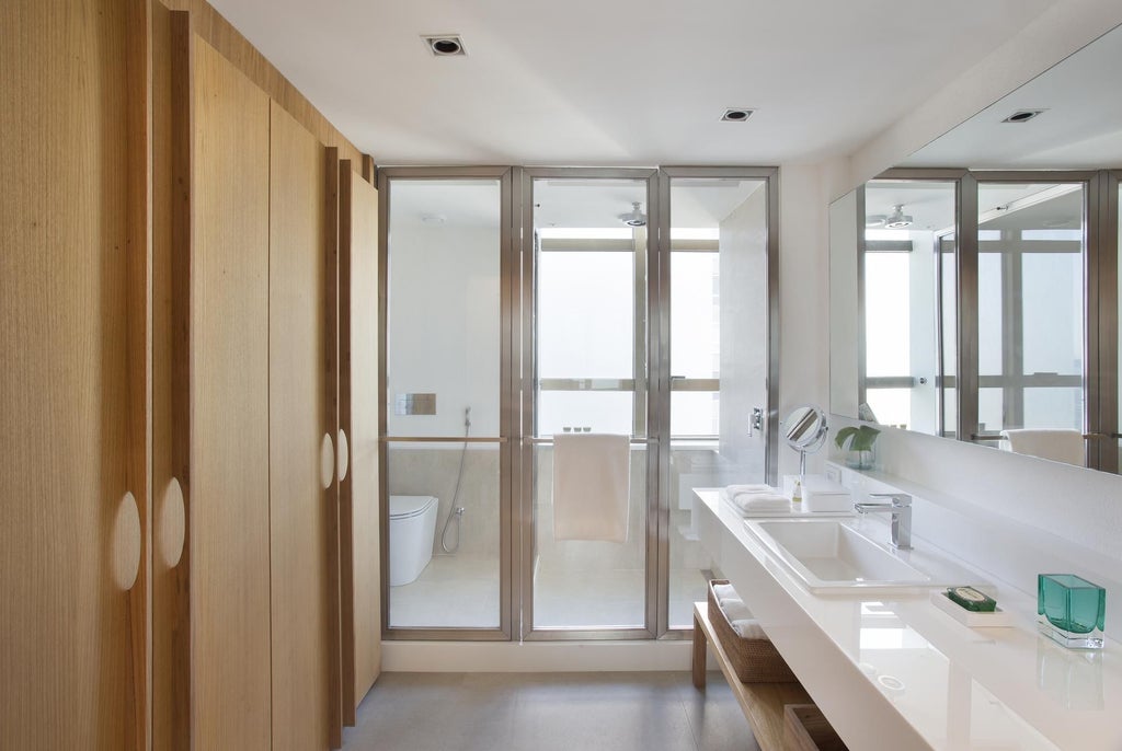 Sleek, modern hotel room at Janeiro Hotel with minimalist design, ocean view, contemporary furniture, and warm neutral color palette in Rio de Janeiro, Brazil