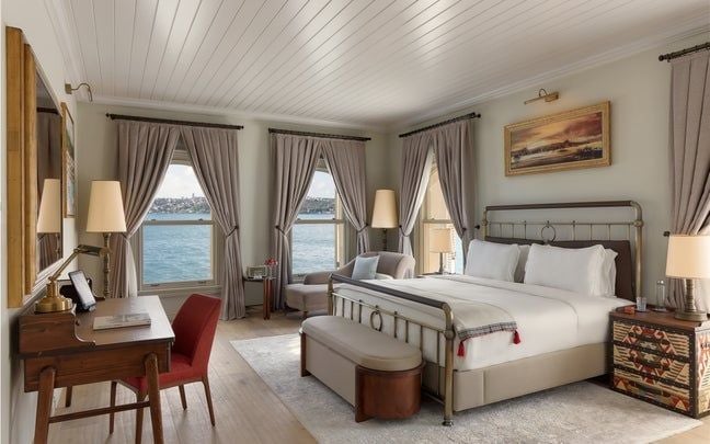 Elegant Bosphorus Deluxe Room with Turkish decor, plush white bedding, panoramic water views, and refined Six Senses luxury design aesthetic