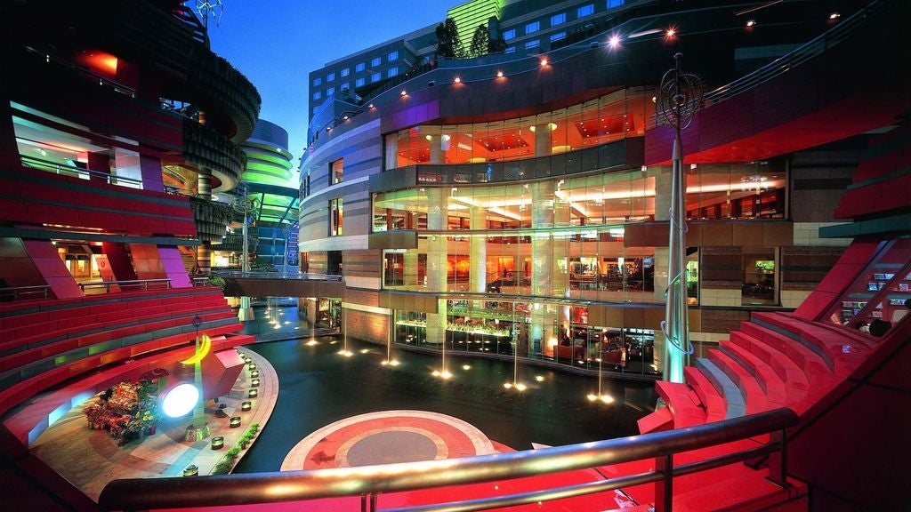 Elegant 5-star hotel facade with massive glass windows, contemporary Japanese architecture, and illuminated signage against evening sky