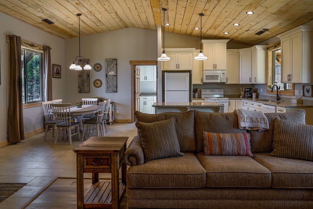 Rustic wooden lodge room with plush bedding, panoramic mountain views, warm earth tones, and elegant southwestern-inspired decor at scenset Mountain Ranch.