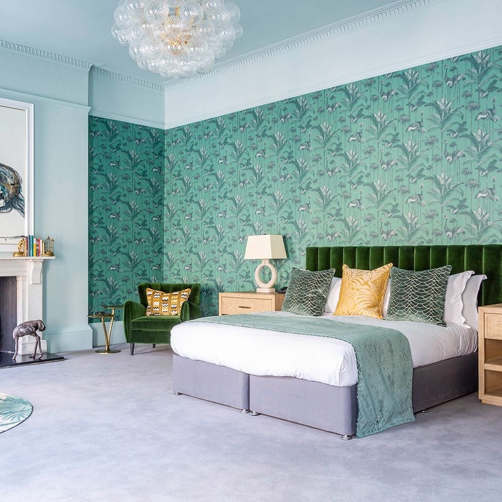 Elegant junior suite with plush white bedding, sophisticated gray headboard, and modern minimalist decor in a stylish United Kingdom boutique hotel room