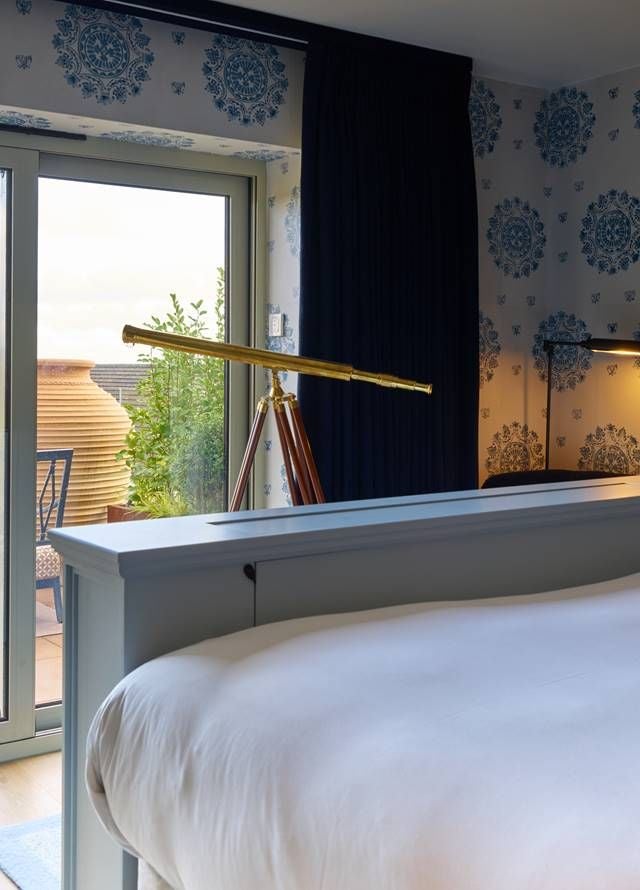 Luxurious hotel room with private hot tub, elegant furnishings, and warm lighting, showcasing contemporary spa-like amenities in a UK boutique accommodation