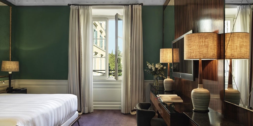 Elegant deluxe double room in J.K. Place Roma, featuring soft neutral tones, plush bedding, and sophisticated Italian design with minimalist decor.