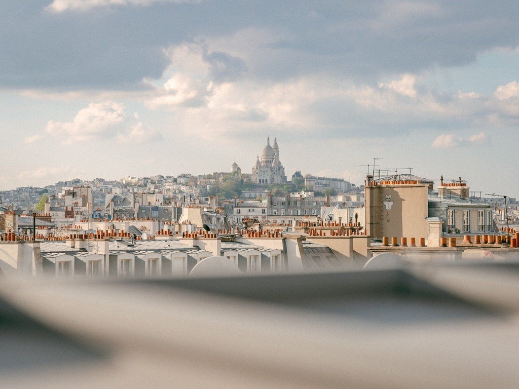 Elegant Parisian hotel facade with classic architectural details, warm stone exterior, and ornate windows reflecting refined French hospitality and design