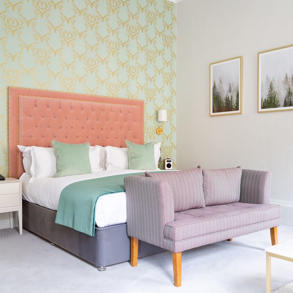 Elegant deluxe hotel room with plush king bed, modern decor, soft gray color palette, and sophisticated lighting in the United Kingdom's boutique accommodation.