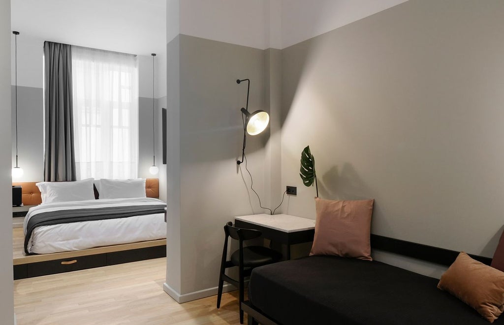 Sleek minimalist hotel room with sophisticated gray color palette, modern furnishings, floor-to-ceiling windows overlooking urban Thessaloniki skyline