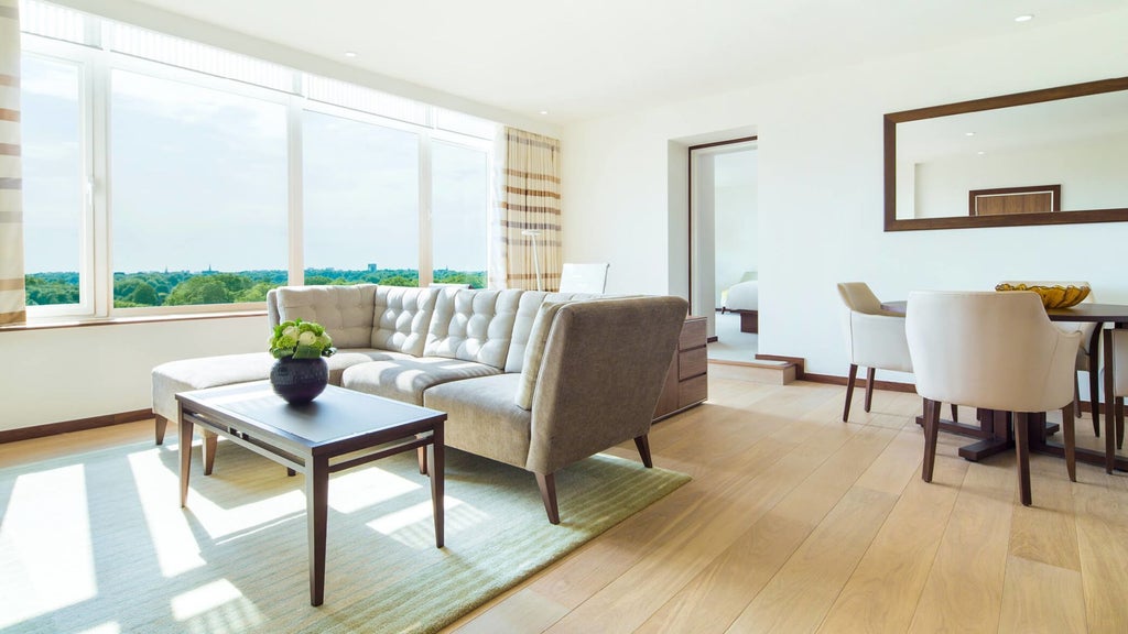 Luxurious COMO Suite at scenset Metropolitan London, featuring elegant contemporary design with plush king bed, city-view windows, and refined neutral color palette